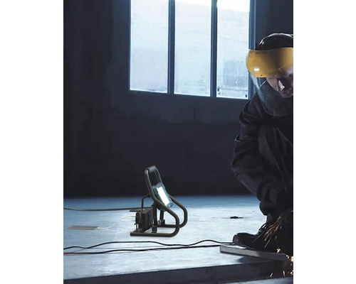 Pracovní lampa v provozu s osobou brousící kov