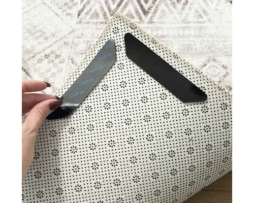 Dva protiskluzové rohy koberce na koberci pro upevnění a fixaci.