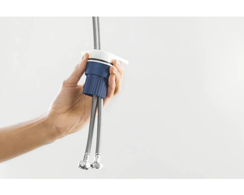 Ruka drží kuchyňskou baterii s připojovacími hadicemi