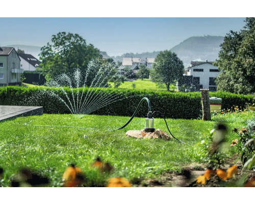 Zahradní krajina se zavlažovačem trávníku a ponorným čerpadlem pro zavlažování zahrady