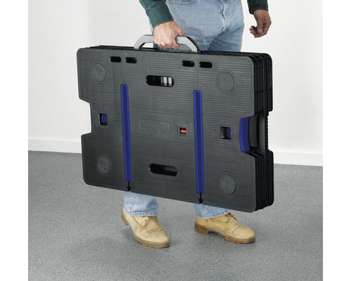 Osoba nesoucí složený pracovní stůl