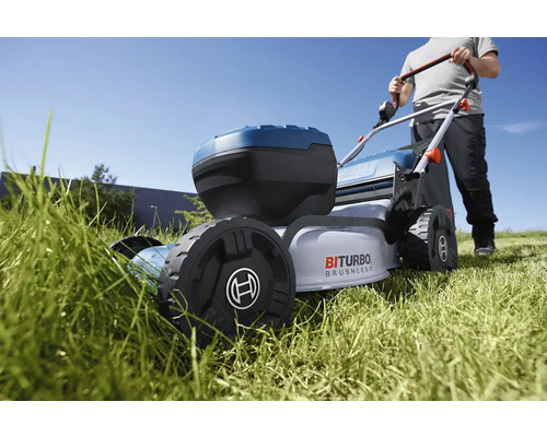 Akumulátorová sekačka na trávu při sekání trávníku na zahradě