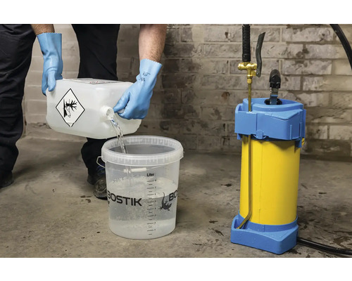 Osoba lije tekutinu z nádoby do kbelíku vedle postřikovače