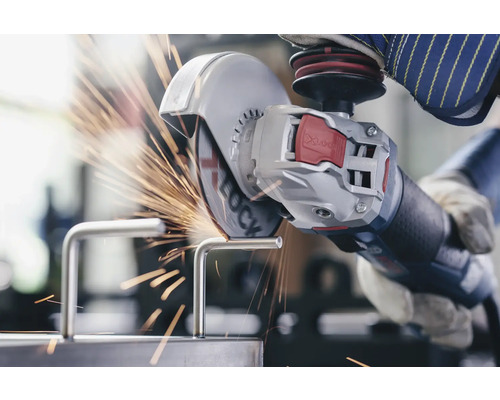 Osoba řeže kovový kus úhlovou bruskou a jiskry létají.