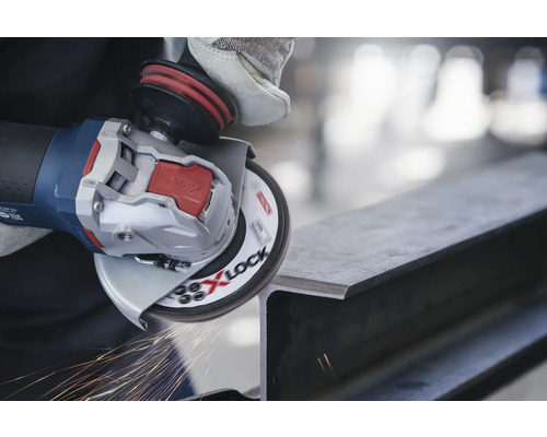 Úhlová bruska s X-Lock brousí kus kovu a jiskří.