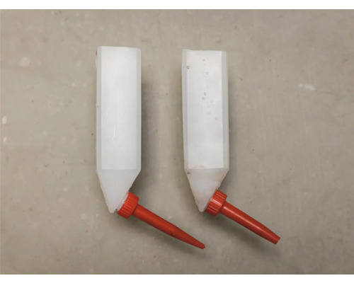 Dva plastové napáječky pro hospodářská zvířata s červeným ventilem