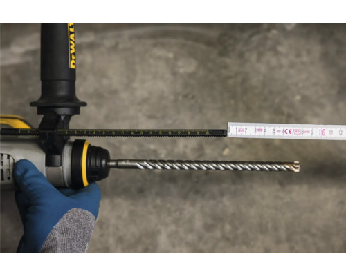 Vrtací stroj s vrtákem a měřicím nástrojem