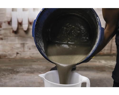 Osoba lije maltu z kbelíku do odměrky.