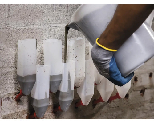 Dělník nalévá maltu do malty na cihlové zdi