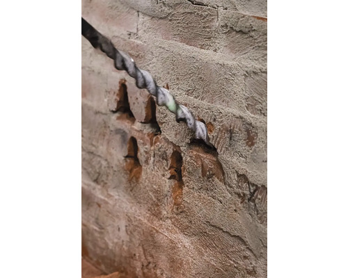 Vrták vrtá otvor do cihlové zdi