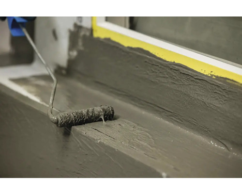 Nanášení těsnění válečkem na parapet.