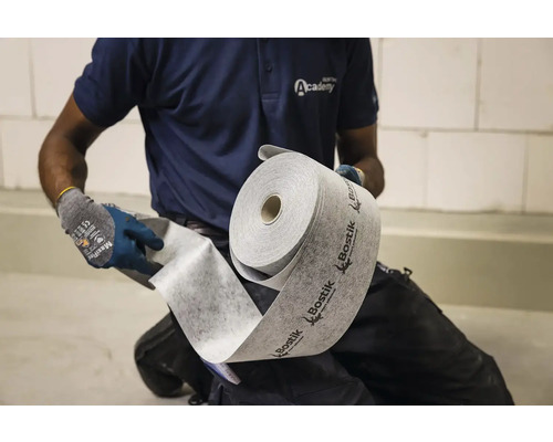 Pracovník drží roli izolační podložky Bostik.