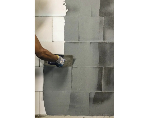 Obkladač s hladítkem při spárování obkladů