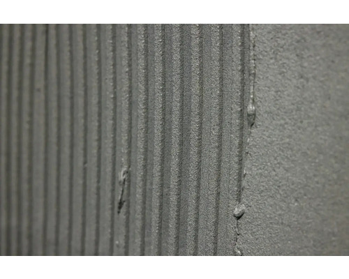 Nanesené lepidlo na obklady s drážkovanou strukturou