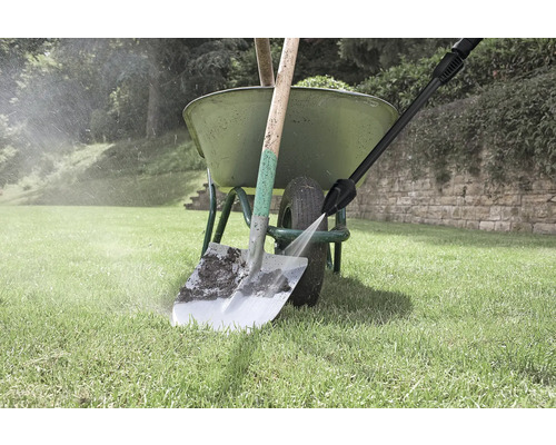 Zahradní scéna: kolečko s lopatou je čištěno vysokotlakým čističem.