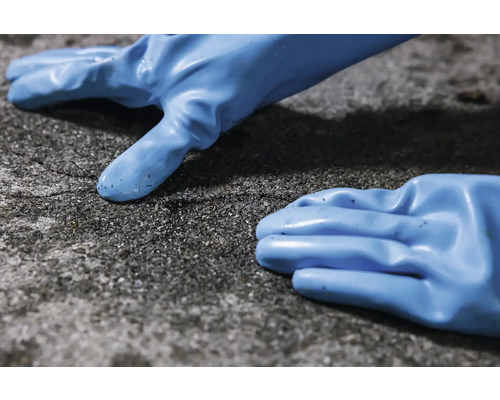 Dvě modré gumové rukavice na drsném povrchu