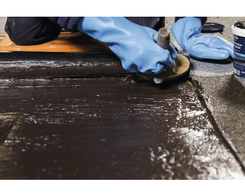 Nanášení bitumenového lepidla na povrch štětcem