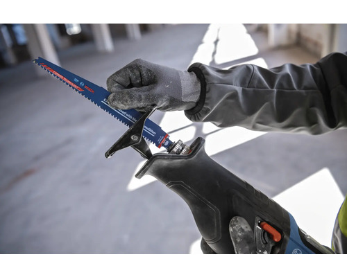 Osoba vkládá pilový list do šavlové pily.