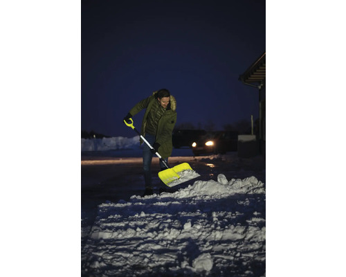 Muž odhazuje sníh lopatou na sníh před domem