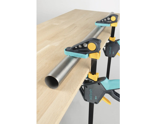 Obrobek připevněný k desce stolu pomocí jednoručních svorek Wolfcraft a trubky.