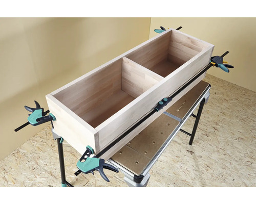 Dřevěná bedna upevněná na pracovní stůl pomocí šroubových svorek