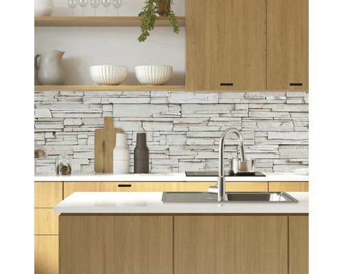 Moderní kuchyně s kamennou stěnou, dřezem a dřevěnými prvky.