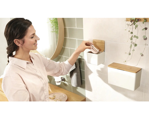 Koupelnová scéna se ženou, umyvadlem a nástěnnými boxy z oceli s bambusovým víkem