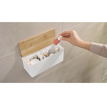 Koupelnový úložný prostor s dřevěným víkem a rukou přidávající lak na nehty