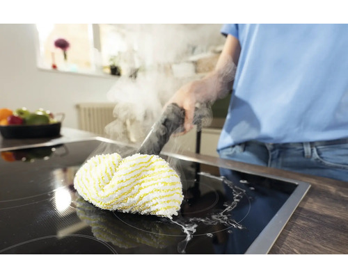 Osoba čistí varnou desku parním čističem.