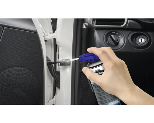 Osoba stříká multifunkční olej na dveřní závěs auta.