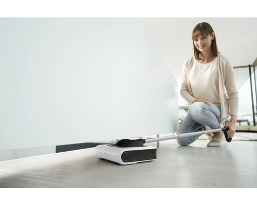 Žena používá elektrický zametač na čištění podlah
