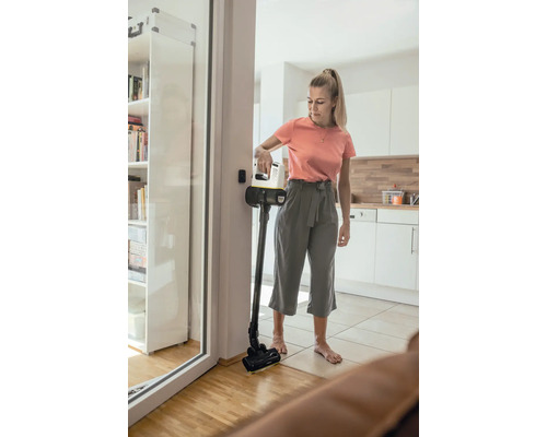 Žena používá akumulátorový vysavač v obývacím pokoji