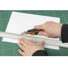 Řezání papíru řezacím nožem a pravítkem na řezací podložce