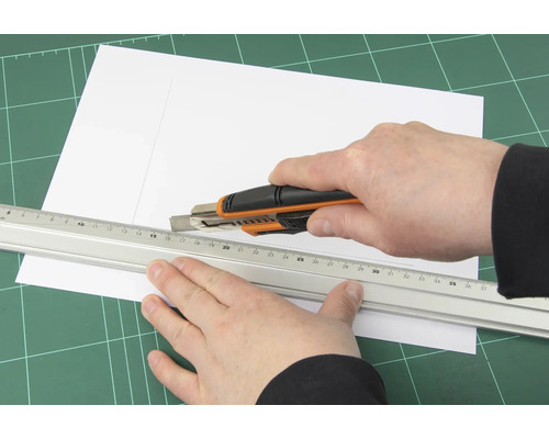 Řezání papíru řezacím nožem a pravítkem na řezací podložce