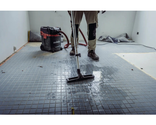 Řemeslník čistí dlažbu mokro-suchým vysavačem Metabo