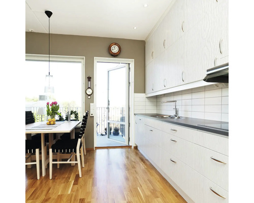 Světlá kuchyně s jídelním stolem a přístupem na balkon.