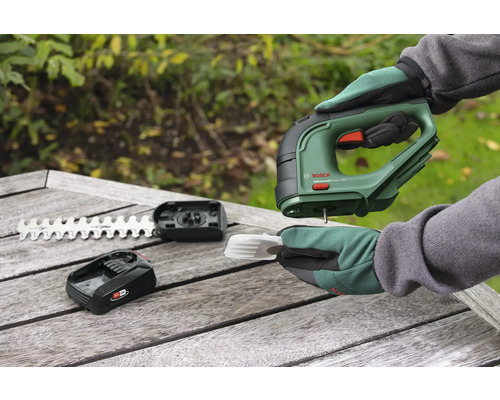 Akumulátorové nůžky s akumulátorem, nožem a příslušenstvím na dřevěném stole