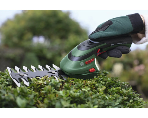 Logo společnosti Bosch. Ruka v zahradní rukavici drží akumulátorové nůžky na trávu nad keřem.