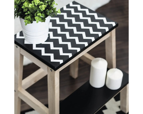 Stolička se stupínkem s cikcakovým vzorem, rostlina a svíčky