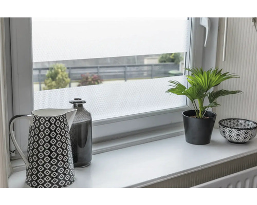 Dekorační fólie na okně s konvicí na kávu, lahví, hrnkovou rostlinou a miskou na okenním parapetu