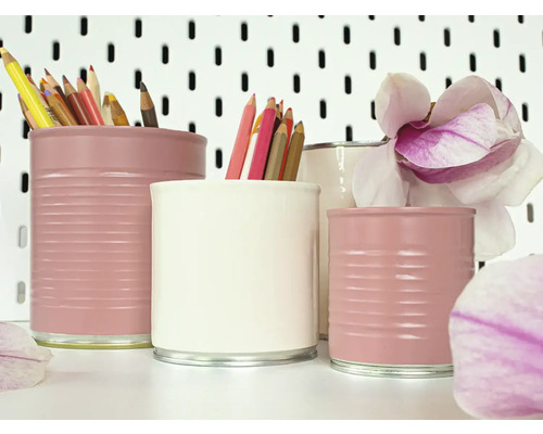 Dekorativní držáky na tužky vyrobené z natřených konzerv s pastelkami a květem magnólie.