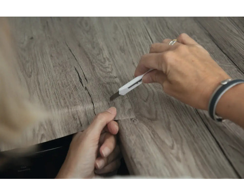 Řezání vinylové podlahy nožem.