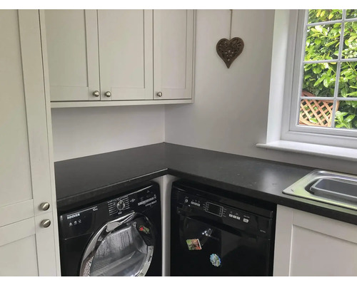 Prádelna s pračkou, sušičkou, myčkou nádobí, umyvadlem a skříněmi