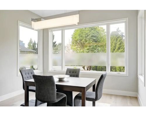 Jídelna se stolem, židlemi a okenní fólií pro větší soukromí