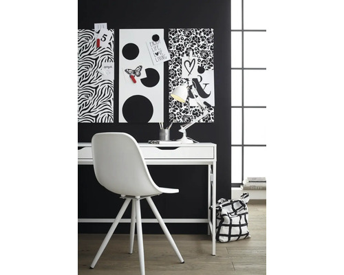 Psací stůl s nástěnkami, lampičkou a židlí v pracovně.