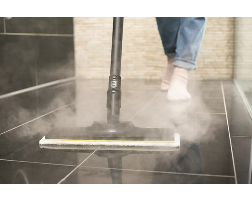 Parní čistič v provozu na dlažbě v koupelně