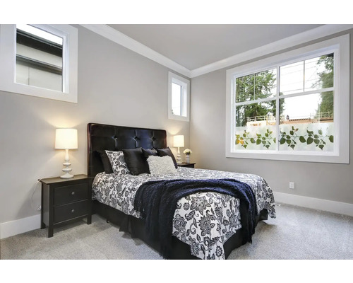 Ložnice s postelí, nočními stolky a oknem s dekorativní fólií