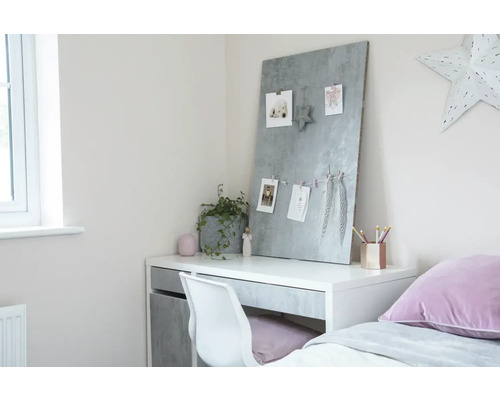 Psací stůl s magnetickou tabulí, židlí a dekorací ve světlém pokoji.