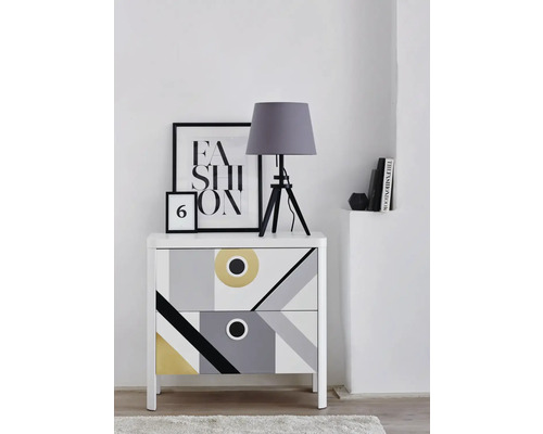 Komoda s geometrickým vzorem, stolní lampa a dekorativní prvky