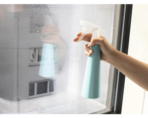 Ruka stříká čistič na okno